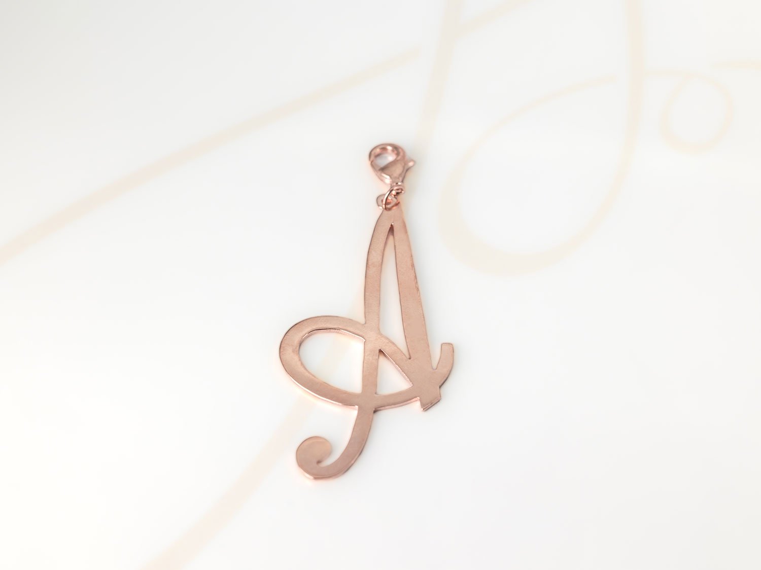DIJE RECUBRIMIENTO DE ORO ROSA CURSIVA A LISO