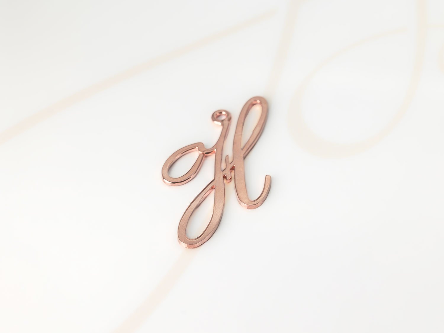 DIJE RECUBRIMIENTO DE ORO ROSA CURSIVA H LISO