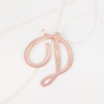 DIJE RECUBRIMIENTO DE ORO ROSA CURSIVA D LISO