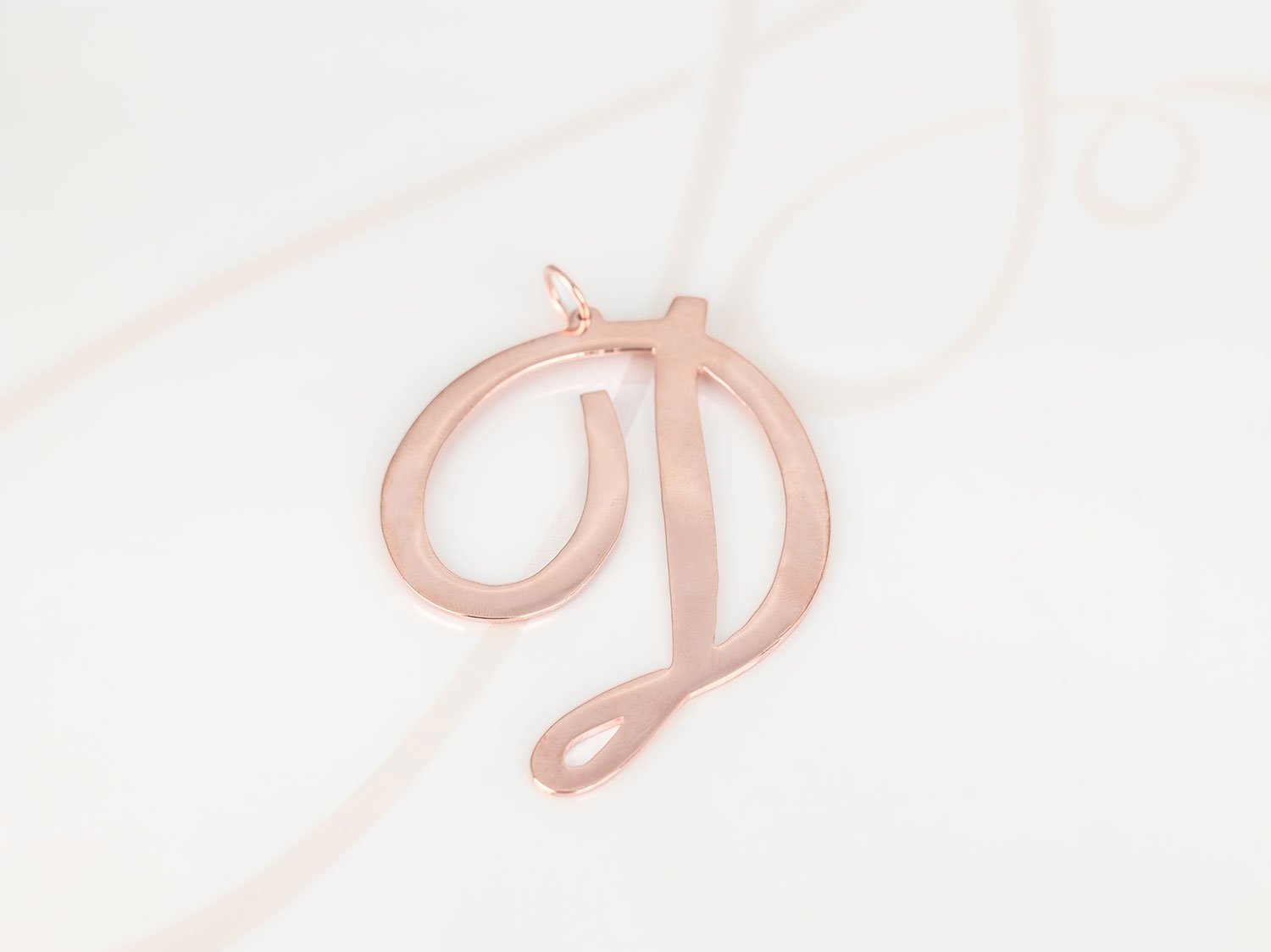 DIJE RECUBRIMIENTO DE ORO ROSA CURSIVA D LISO