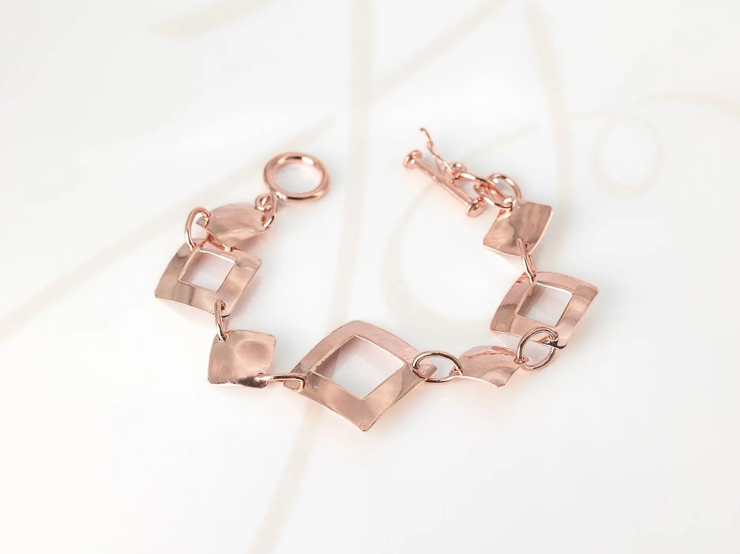 PULSERA SIN DIJE RECUBRIMIENTO DE ORO ROSA ROMBOS ASIMETRICOS LISO